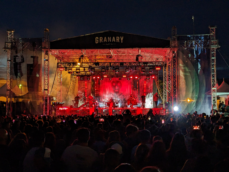Nighttime concert at Granary Live with full audience, large stage rig, and dramatic lighting effects illuminating the scene.